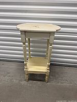 Full view of cream distressed wood side table