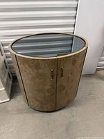 Front 3/4 view of cabinet closed showing burl veneer and glass top