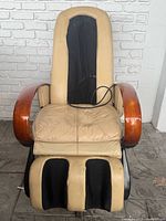 Front view of beige and black Human Touch HTT-10CRPC massage chair showing wear on seat and armrests
