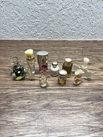 Group shot of all eleven perfume bottles showing sizes, shapes and residual contents