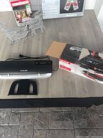 Laminator with exit tray and Uline pouch box on tabletop