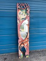 Entire mirror showing carved wooden frame with giraffe and parrot figures