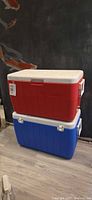 Red cooler stacked on blue cooler showing overall appearance, colors and handles