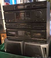 Front view of stacked Pioneer components atop Aiwa speakers