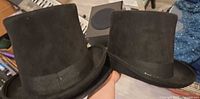 Two black top hats side by side