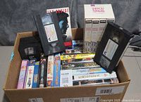 Box filled with assorted VHS tapes, some without cases