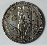 Reverse side of 1958 Canadian silver dollar showing totem pole design and inscriptions