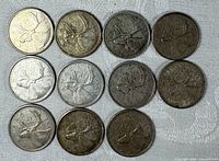 Front view of 11 circulated 1964 Canadian quarters
