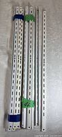 Set of white steel slotted uprights bundled together
