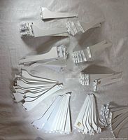 Assortment of white metal shelf brackets grouped on surface