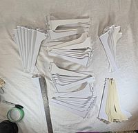 Grouped white and off-white metal brackets laid out for count and condition visibility