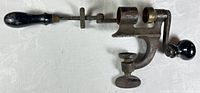 Full side view showing complete antique roll crimper with handle and clamp