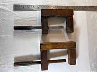 two small clamps stacked, ruler for scale