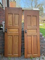 Front view of both matching wooden doors standing side by side
