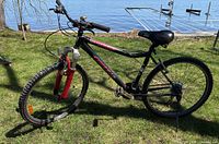 Right side profile of black Bonelli Trappeur FS mountain bike by lakeside