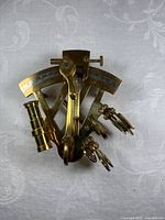 Top view of brass sextant showing index arm, telescope, filters and graduated arc