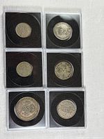 Fronts of six British coins in holders