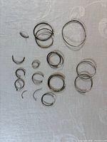 All silver-tone hoop earrings and segments laid out for overview
