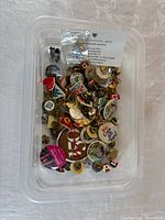 Plastic tub filled with assorted pins and buttons