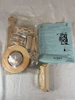 Sealed plastic bag of wooden parts, blue instruction booklet, wrapped hardware pack