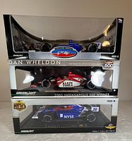 Stacked view of three boxed 1:18 IndyCar models