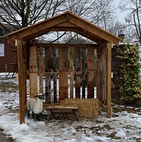 assembled wooden creche showing slat walls and pitched roof