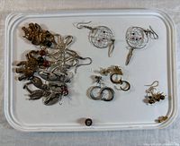 All earrings laid out showing variety of styles and motifs