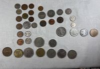 Full lot of roughly 32 assorted coins laid out on cloth