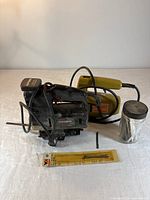 Craftsman jigsaw, Black & Decker jigsaw, jar of blades, blister pack blades on table