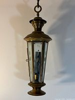 Full view of brass lantern hanging against wall