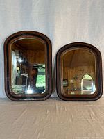 Front view of both antique mirrors showing matching frames and wavy glass