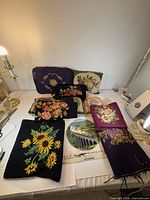 Group shot of all needlepoint pillows and panels on table