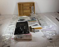 overview of lot with wooden tray, bags of type, holder, ruler, black case