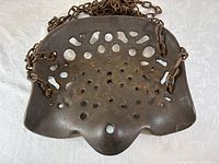 Front view of cast iron tractor seat with attached chains