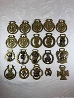 Front view of all 19 brass medallions laid out in rows