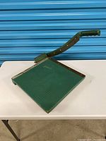 Full view of guillotine paper cutter showing base and cutting arm