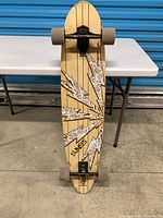 Full view of the complete Fanatic pintail longboard standing upright