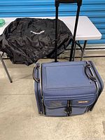 overall view of blue rolling tote with telescoping handle and black Fiskars cover