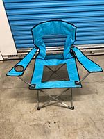 Front view of blue folding chair showing mesh panels and cup holder