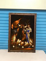 Front view of framed velvet painting showing bull and matador imagery