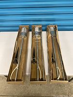 Three sealed IKEA lamp boxes displayed side by side