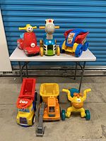 All six ride-on toys grouped together on floor and table