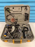 Open case showing spin saw, cord, flexible shaft, side handle, discs, adapters and accessories