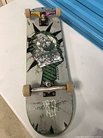 Overall view of skateboard bottom with graphic, trucks and wheels visible