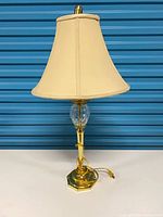 Full view of brass and glass table lamp with shade