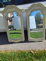Front view of both matching arched mirrors leaning against vehicle