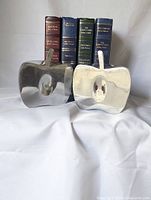 Front view of both aluminum apple bookends with books placed between for scale