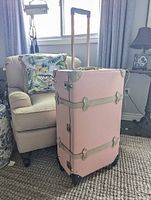 Full view of pink Steamline suitcase standing upright with telescopic handle extended
