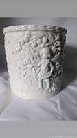 Front view of white ceramic cachepot showing raised fairy and floral design