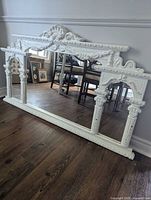 Front view of entire mirror showing ornate frame and reflective glass